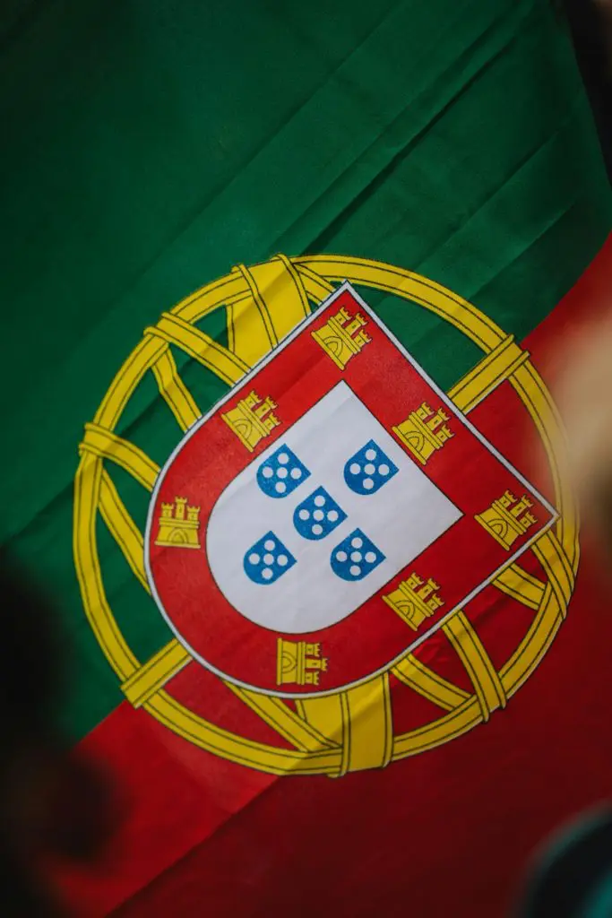 Bandeira de Portugal com brasão nacional visível.